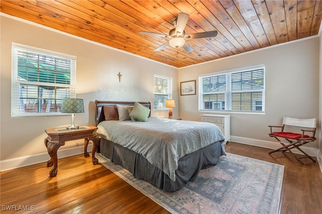 bedroom with wood ceiling, crown molding, baseboards, and wood finished floors