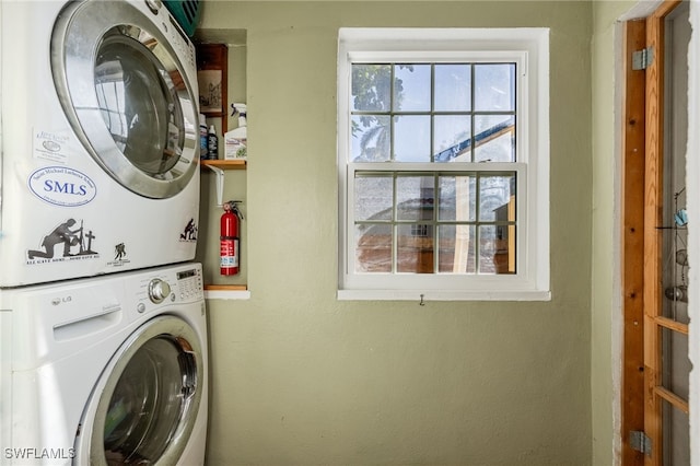 clothes washing area featuring stacked washer / dryer