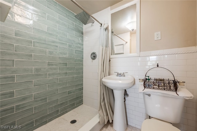 bathroom featuring toilet, a shower with shower curtain, and tile walls