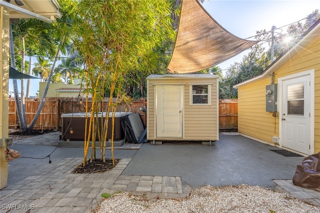 view of shed featuring a fenced backyard and a hot tub