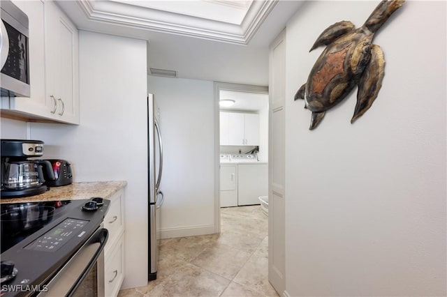 kitchen with separate washer and dryer, white cabinetry, light tile patterned flooring, and stainless steel appliances