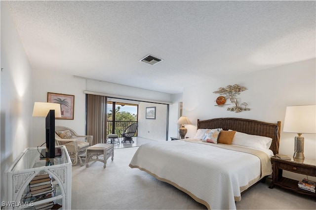 bedroom with access to exterior, light colored carpet, and a textured ceiling