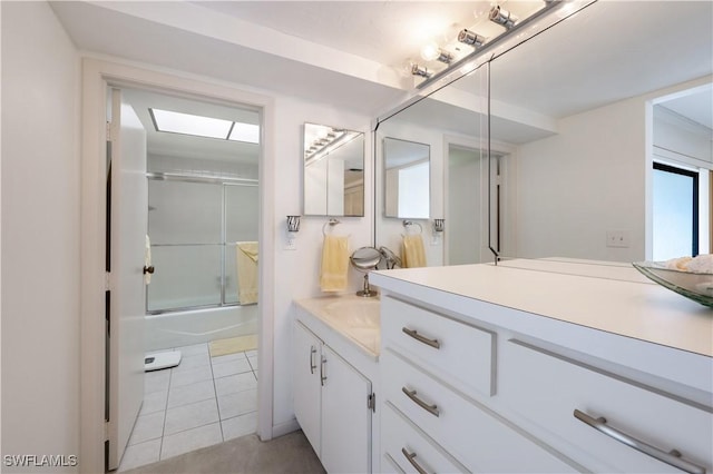 bathroom featuring vanity, tile patterned floors, and bath / shower combo with glass door