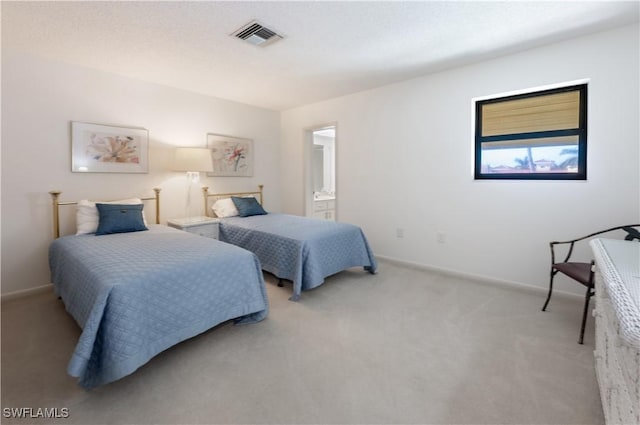 carpeted bedroom featuring ensuite bath