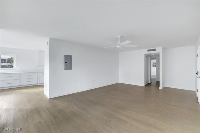 empty room featuring ceiling fan, wood-type flooring, and electric panel