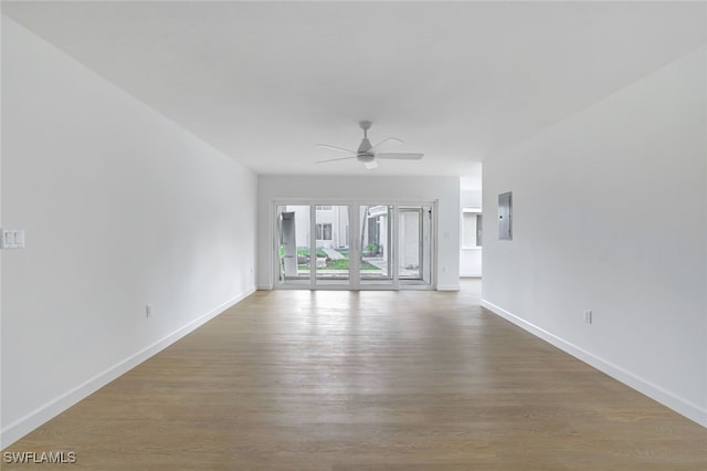 spare room with electric panel, ceiling fan, and hardwood / wood-style floors