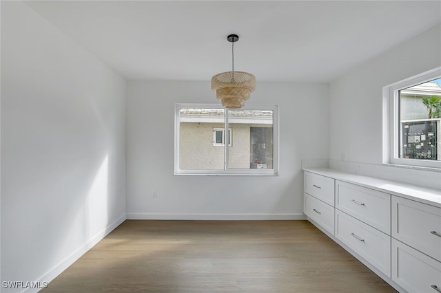 unfurnished dining area featuring light wood-type flooring