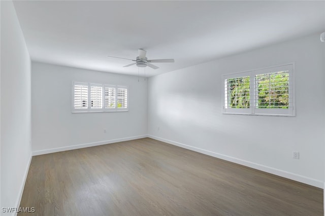 unfurnished room with dark hardwood / wood-style floors, plenty of natural light, and ceiling fan