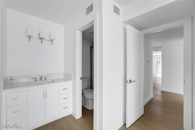 bathroom featuring hardwood / wood-style floors, vanity, and toilet