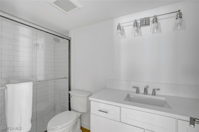 bathroom featuring vanity, toilet, and a shower with door