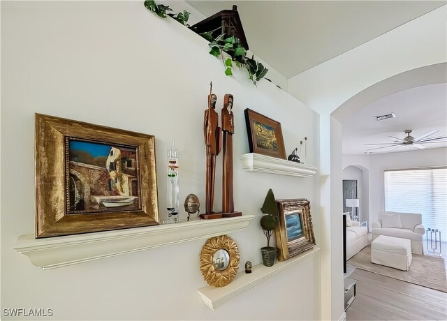 interior details with visible vents, arched walkways, wood finished floors, and a ceiling fan