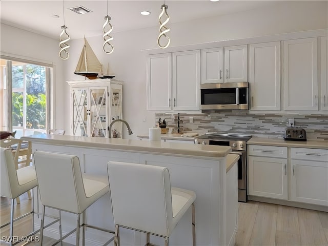 kitchen with visible vents, appliances with stainless steel finishes, decorative backsplash, and light countertops