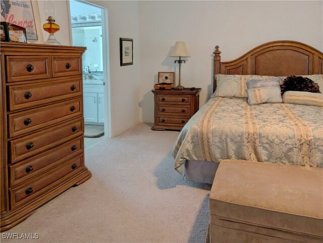 bedroom with ensuite bath and carpet floors