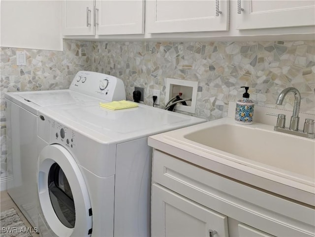 clothes washing area featuring washer and dryer, cabinet space, and a sink