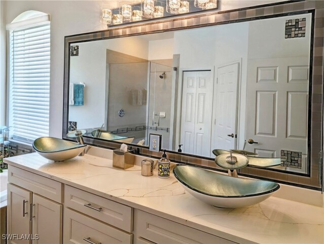 bathroom featuring a shower stall, a healthy amount of sunlight, and a sink