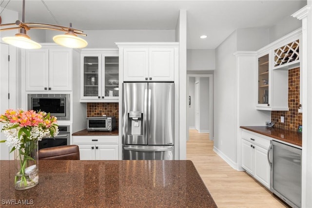 kitchen featuring white cabinetry, backsplash, and appliances with stainless steel finishes