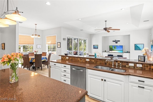 kitchen with sink, white cabinets, a healthy amount of sunlight, and decorative light fixtures