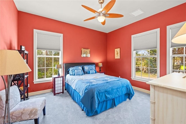 bedroom featuring carpet flooring, ceiling fan, and multiple windows