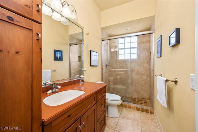 bathroom featuring toilet, a shower with door, vanity, and tile patterned flooring