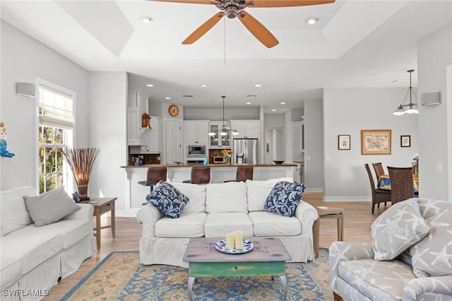 living room with ceiling fan and light hardwood / wood-style flooring