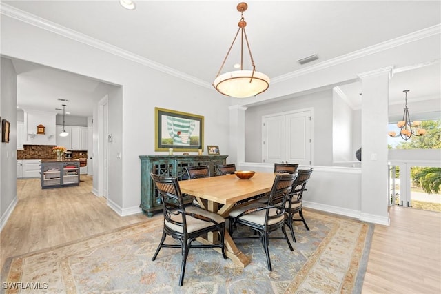 dining space with an inviting chandelier, light hardwood / wood-style flooring, and ornamental molding