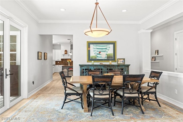 dining room featuring light hardwood / wood-style flooring, french doors, and ornamental molding