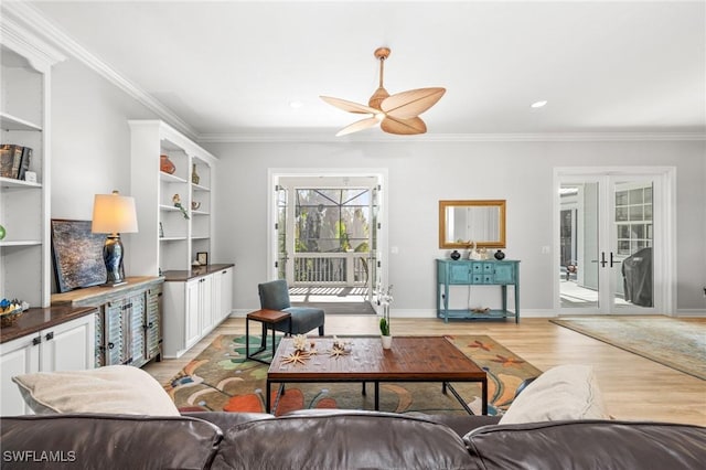 living room with french doors, light hardwood / wood-style floors, ceiling fan, and crown molding