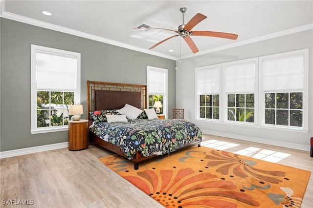 bedroom with multiple windows, light hardwood / wood-style flooring, ceiling fan, and ornamental molding