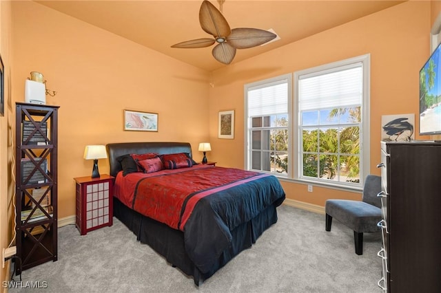 carpeted bedroom with ceiling fan, vaulted ceiling, and multiple windows