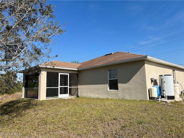 back of house with a sunroom and a lawn