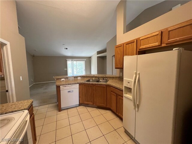 kitchen featuring kitchen peninsula, vaulted ceiling, sink, and white appliances