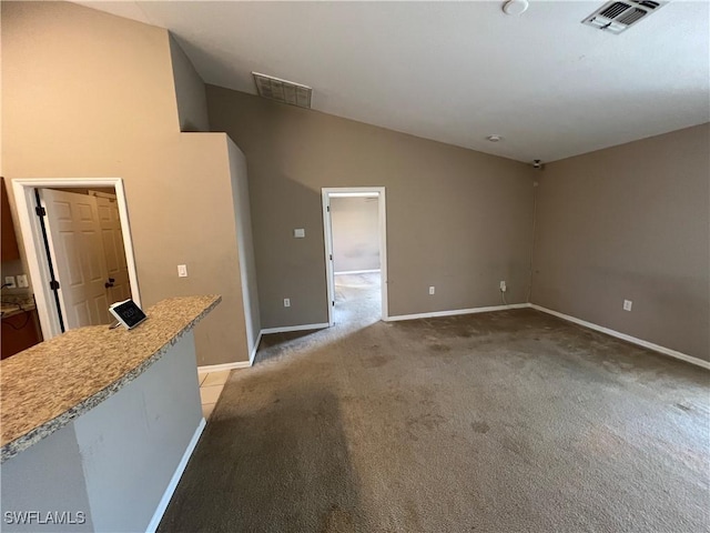 unfurnished living room featuring light carpet and vaulted ceiling