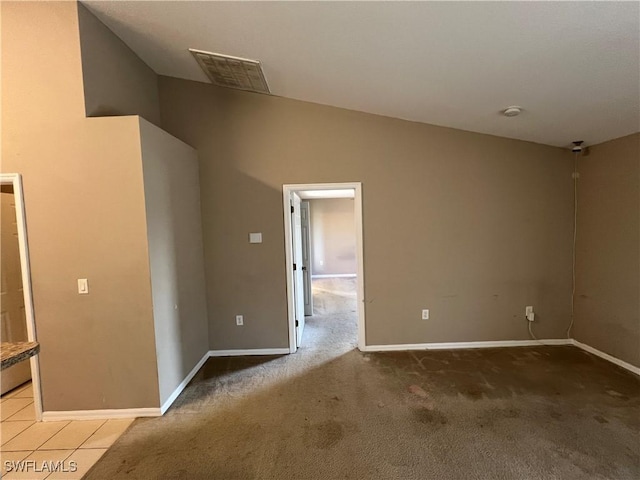 carpeted spare room featuring vaulted ceiling