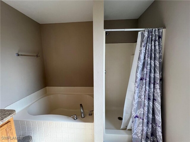 bathroom featuring shower with separate bathtub and vanity