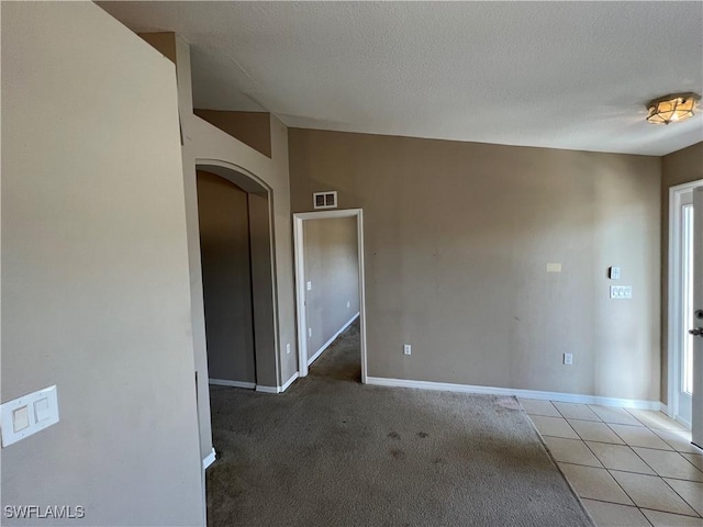 carpeted spare room with a textured ceiling