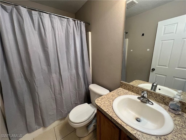 bathroom featuring toilet, vanity, and tile patterned floors