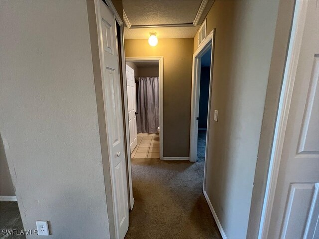 corridor featuring a textured ceiling and carpet flooring