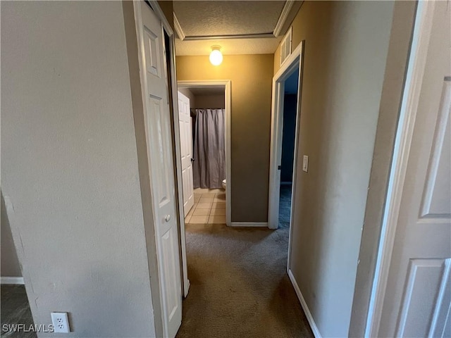 corridor with carpet flooring and a textured ceiling