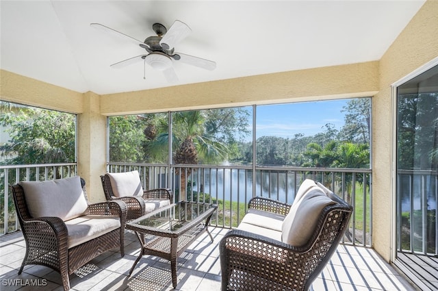 sunroom featuring ceiling fan, a water view, and vaulted ceiling