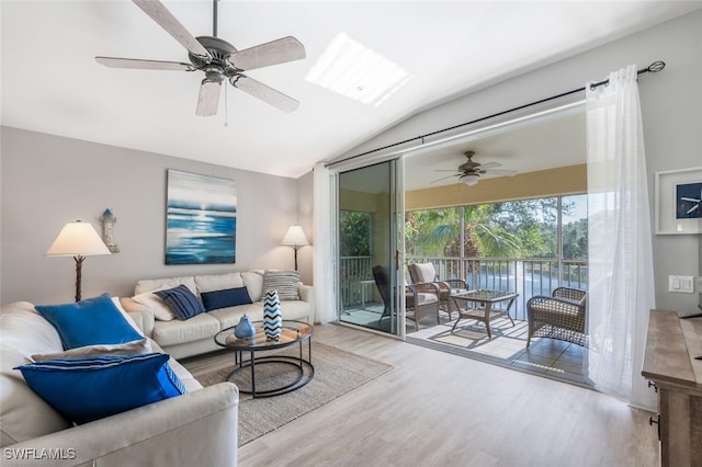 living room featuring ceiling fan, lofted ceiling, and light hardwood / wood-style flooring