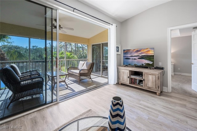 interior space with ceiling fan, light hardwood / wood-style floors, and vaulted ceiling