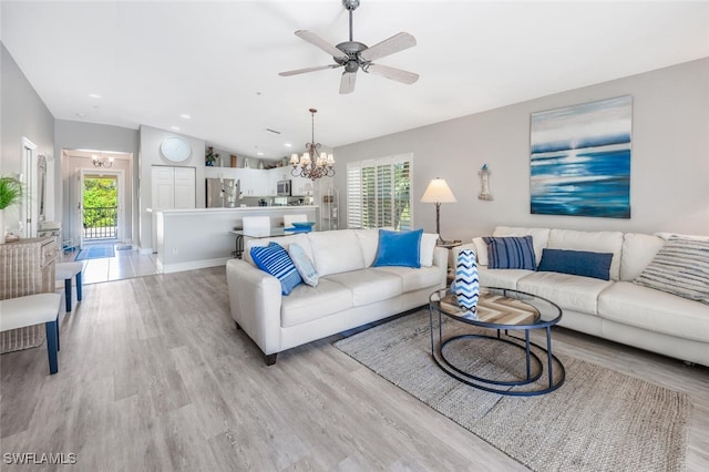 living room featuring lofted ceiling, a wealth of natural light, and light hardwood / wood-style flooring