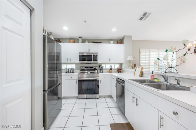 kitchen with white cabinetry, sink, light tile patterned floors, and appliances with stainless steel finishes