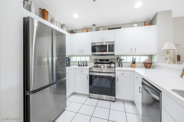 kitchen featuring white cabinets, light tile patterned flooring, and stainless steel appliances