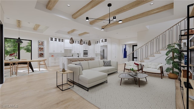 living room featuring beam ceiling, light wood-type flooring, a notable chandelier, and sink