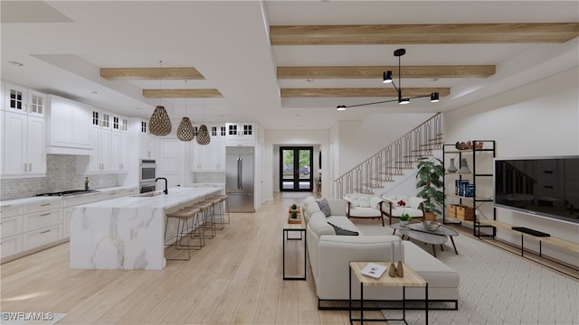 living room featuring beamed ceiling, light wood-type flooring, and sink