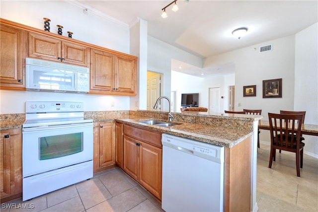 kitchen featuring kitchen peninsula, light tile patterned floors, white appliances, and sink