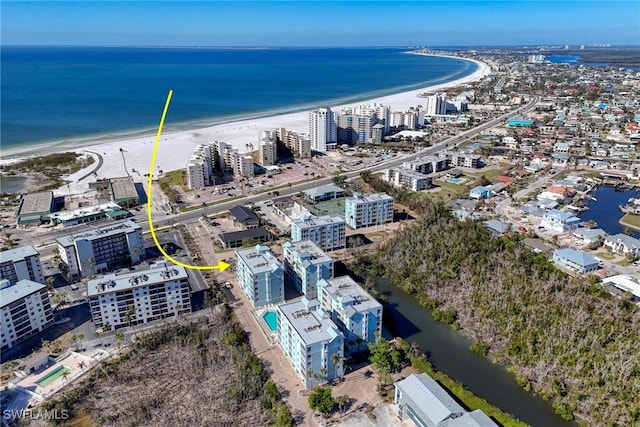 birds eye view of property with a water view and a beach view