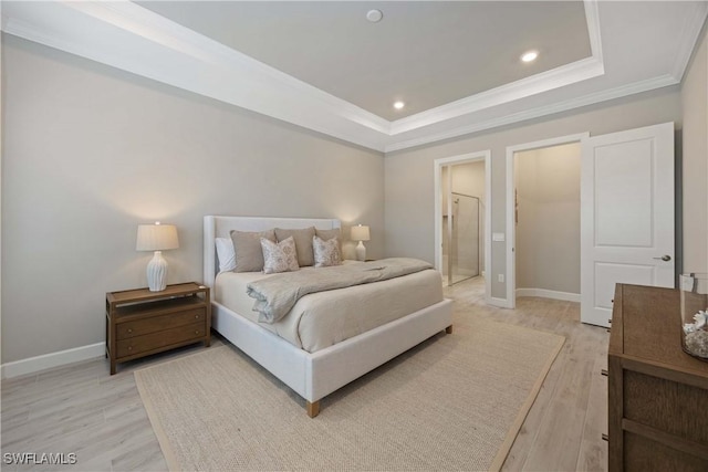 bedroom with a tray ceiling, crown molding, and light hardwood / wood-style floors