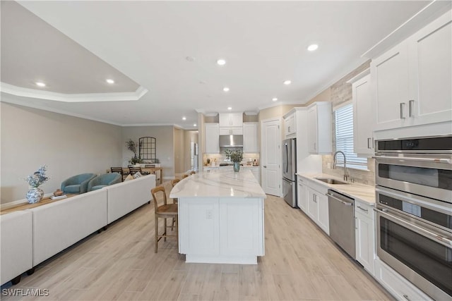 kitchen featuring a large island, sink, white cabinets, and appliances with stainless steel finishes